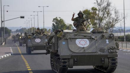 Ein israelischer Soldat zeigt das Victory-Zeichen von einem gepanzerten Mannschaftstransportwagen aus, der sich im Süden Israels auf die Grenze zum Gazastreifen zubewegt. 