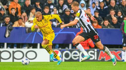 Dan Burn von Newcastle United und Donyell Malen von Borussia Dortmund während des Spiels. 