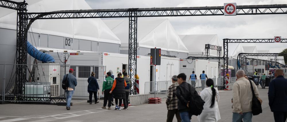Bewohner und Mitarbeiter gehen im Ankunftszentrum am ehemaligen Flughafen Tegel in Richtung der Leichtbauhallen. (zu dpa "Langzeitauswertung - Angekommen, und nun? - Leben in einer beengten Flüchtlingsunterkunft") +++ dpa-Bildfunk +++