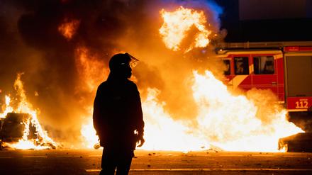 Randale in der Silvesternacht in Kreuzberg und Neukölln. Ein Polizist steht vor einer brennenden Barrikade aus Mülltonnen und Mietrollern an der Kreuzung Urbanstraße / Graefestraße. Berlin, Deutschland, 01.01.2023.

[© Christian Mang - Veroeffentlichung nur gg. Honorar (zzgl. MwSt.), Urhebervermerk und Beleg. Nur für redaktionelle Nutzung - Publication only with licence fee payment, copyright notice and voucher copy. For editorial use only - No model release. No property release. Kontakt: mail@christianmang.com.]