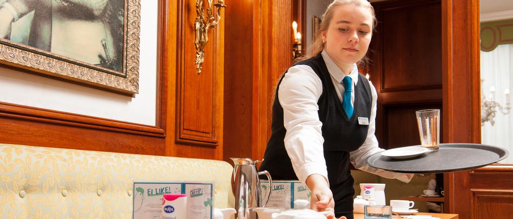 Sophie Cyriax beim Abräumen eines Frühstücktischs.