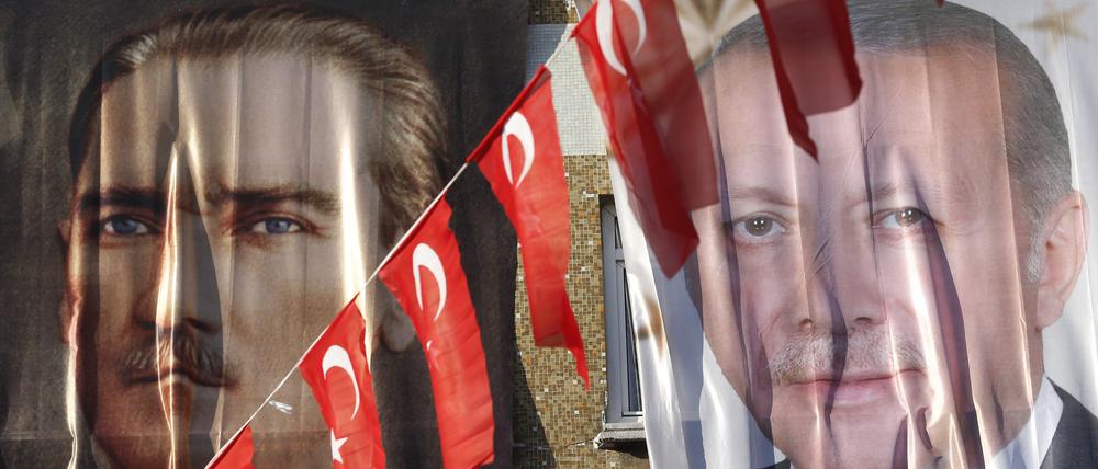 Eine Frau blickt aus einem Fenster hinter einem Banner des türkischen Staatsgründers Atatürk (l) und des türkischen Präsidenten Erdogan.
