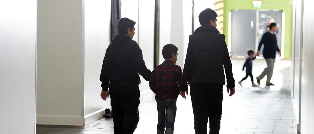 ARCHIV - Flüchtlinge gehen am 25.02.2016 in der Notunterkunft für Flüchtlinge am Tempelhofer Feld in Berlin zwischen den Stellwänden entlang. Foto: Rainer Jensen/dpa (zu dpa-KORR "Ab auf die Couch? Viele Flüchtlinge brauchen andere Hilfen" vom 04.08.2016) +++ dpa-Bildfunk +++