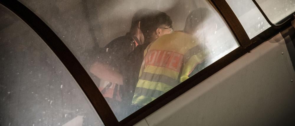 Polizeibeamte begleiten einen Menschen auf dem Flughafen Leipzig-Halle in ein Charterflugzeug für eine Abschiebung.