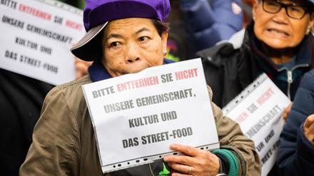 Eine Frau hält bei einer Demonstration für den Erhalt des Thaimarkts im Preußenpark des «Thailändischen Vereins in Berlin» und der SPD Charlottenburg-Wilmersdorf ein Schild. Darauf ist zu lesen «Bitte entfernen Sie nicht unsere Gemeinschaft, Kultur und das Street-Food».
