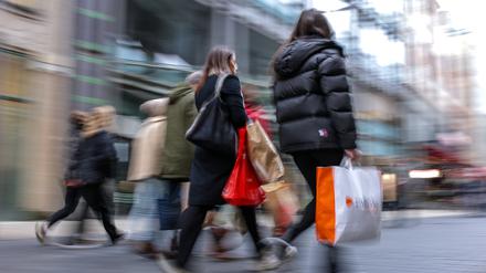 Passanten gehen mit mehreren Einkaufstüten durch die Leipziger Innenstadt. 
