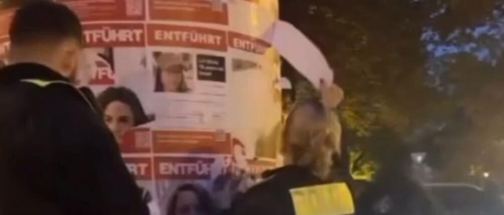 Ein Video zeigt, wie Beamte der Polizei Berlin am 26, Oktober 2023 in Friedrichshain Plakat von einer Litfaßsäule abreißen. Sie zeigen Menschen, die von der Hamas beim Angriff auf Israel am 7. Oktober nach Gaza verschleppt und dort als Geiseln gehalten werden.
