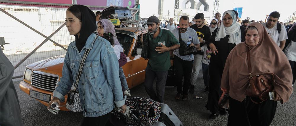 Palästinenser tragen Gepäck am Grenzübergang zwischen dem Gazastreifen und Ägypten.