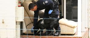 02.11.2023, Australien, Wonthaggi: Ein Polizeibeamter und ein Hund sind auf dem Grundstück von Erin Patterson in Leongatha, Victoria, zu sehen. Erin Patterson wurde im Rahmen der Ermittlungen zu einer mutmaßlichen Pilzvergiftung, bei der drei Menschen starben und ein weiterer schwer erkrankte, in ihrem Haus festgenommen.