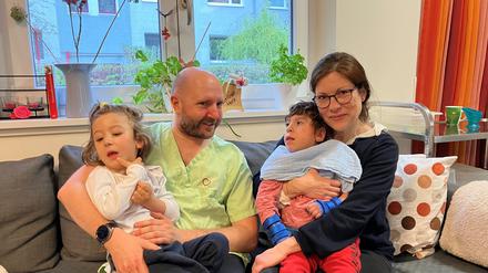 Kuscheln in der Wohnküche: Pflegefachkraft Dominic R. mit Niccolo, Katja Schröther mit Gabriel