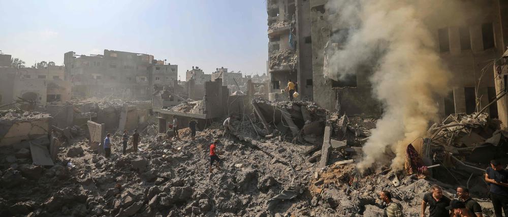 Menschen durchsieben die schwelenden Trümmer von Gebäuden, die bei einem israelischen Angriff auf das Flüchtlingslager Bureij im zentralen Gazastreifen am 2. November 2023 zerstört wurden.