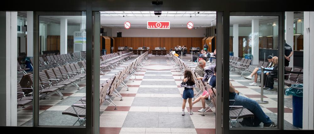 Menschen sitzen in der Ankunftshalle für Geflüchtete im Landesamt für Flüchtlingsangelegenheiten. (Archivbild)