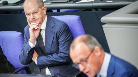 Friedrich Merz (r), CDU-Bundesvorsitzender und Unionsfraktionsvorsitzender, spricht neben Bundeskanzler Olaf Scholz (SPD) im Plenum des Bundestags nach der Regierungserklärung des Bundeskanzlers. +++ dpa-Bildfunk +++