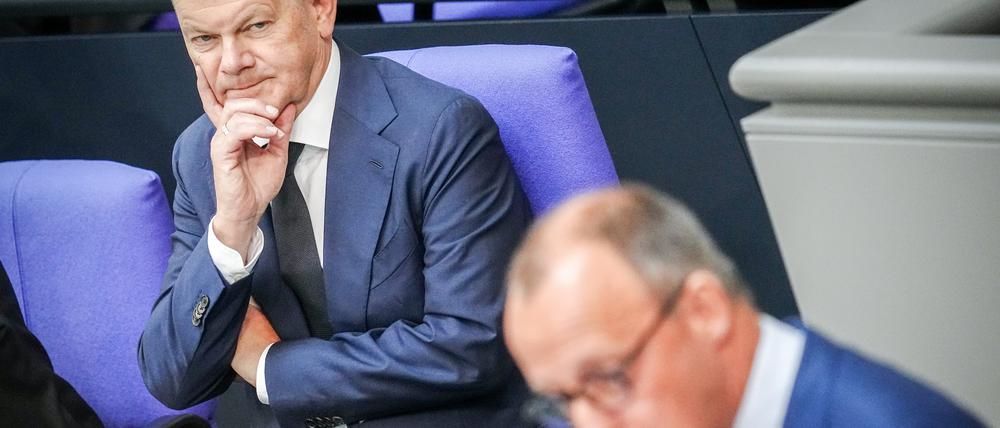 Friedrich Merz (r), CDU-Bundesvorsitzender und Unionsfraktionsvorsitzender, spricht neben Bundeskanzler Olaf Scholz (SPD) im Plenum des Bundestags nach der Regierungserklärung des Bundeskanzlers. +++ dpa-Bildfunk +++