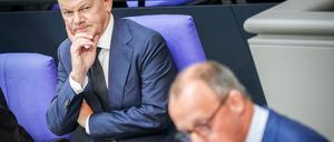 Friedrich Merz (r), CDU-Bundesvorsitzender und Unionsfraktionsvorsitzender, spricht neben Bundeskanzler Olaf Scholz (SPD) im Plenum des Bundestags nach der Regierungserklärung des Bundeskanzlers. +++ dpa-Bildfunk +++