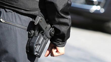 Polizei Symbolbild Polizist von hinten mit Schusswaffe und kugelsicherer Weste in Nahaufnahme als Symbolbild bei strahlendem Sonnenschein am 02.04.19 in Berlin Berlin Berlin Deutschland *** Police symbol police officer from behind with firearm and bulletproof vest in close-up as symbol picture in bright sunshine on 02 04 19 in Berlin Berlin Berlin Germany  