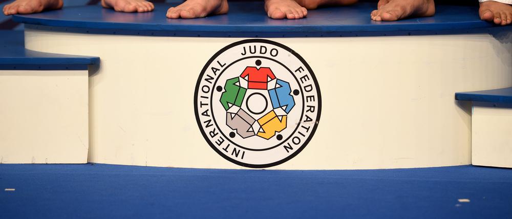 Symbolbild. Die Füße der Judoka in der Gewichtsklasse der Frauen über 78kg sind während der Siegerehrung auf dem Podest mit dem Logo der International Judo Federation zu sehen.