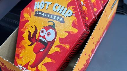 Mehrerer Packungen der „Hot Chip Challenge“ liegen bei einem Kiosk neben der Kasse.