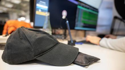 Eine Baseballmütze liegt in einem Coworking-Space auf dem Tisch eines Programmierers (Symbolfoto).