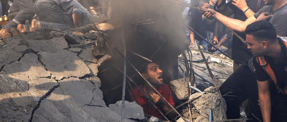 Palästinenser suchen in Khan Younis im südlichen Gazastreifen unter Trümmern nach Überlebenden.  Israel bombardiert auch regelmäßig den Südteil des Landstrichs, in den die Bevölkerung aus dem Norden flüchten soll.