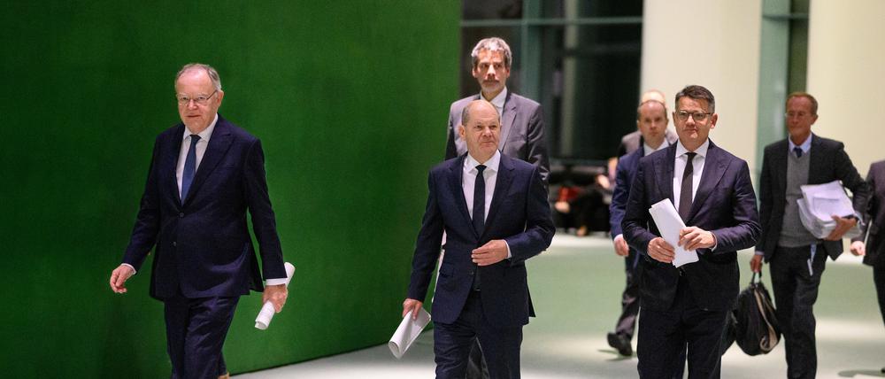 Bundeskanzler Olaf Scholz (M, SPD) kommt zusammen mit Boris Rhein (r, CDU), Ministerpräsident von Hessen, und Stephan Weil (l, SPD), Ministerpräsident von Niedersachsen, zu einer Pressekonferenz nach dem Bund-Länder-Gipfel im Bundeskanzleramt.
