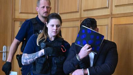 Ein Angeklagter (r) wird vor Beginn seiner Verhandlung in den Gerichtssaal im Landgericht Heilbronn geführt. 