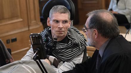 Harald Mayer, durch Multiple Sklerose komplett bewegungsunfähig, sitzt neben Robert Roßbauch, Rechtsanwalt, in einem Saal des Bundesverwaltungsgerichtes (BVerwG). Mayer wünscht sich Sterbehilfe.  