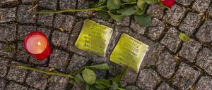 Rosen und eine Kerze liegen neben zwei Stolpersteinen in der Bahnhofstraße in Königs Wusterhausen Dahme-Spreewald. Die Stolpersteine sind ein Projekt des Künstlers Gunter Demnig, das im Jahr 1992 begann. Mit im Boden verlegten kleinen Gedenktafeln, sogenannten Stolpersteinen, soll an das Schicksal der Menschen erinnert werden, die in der Zeit des Nationalsozialismus NS-Zeit verfolgt, ermordet, deportiert, vertrieben oder in den Suizid getrieben wurden Foto: Volker Hohlfeld Stolpersteine *** Roses and a candle lie next to two Stolpersteine in the Bahnhofstraße in Königs Wusterhausen Dahme Spreewald The Stolpersteine are a project by the artist Gunter Demnig, which began in 1992 With small memorial plaques laid in the ground, so-call