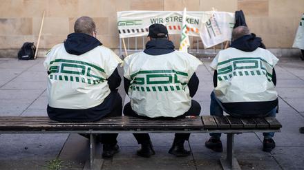 Teilnehmer eines Warnstreiks der Gewerkschaft Deutscher Lokomotivführer (GDL) im Jahr 2022 sitzen vor dem Heilbronner Hauptbahnhof auf einer Bank.