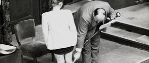 Leo Alexander demonstriert an einer der polnischen Frauen, die in Nürnberg als Zeugin auftraten, Taten der NS-Ärzte.