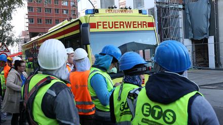 Einsatzfahrzeuge der Feuerwehr und Bauarbeiter stehen vor einer Baustelle. Nach dem schweren Unfall auf einer Großbaustelle in der Hamburger Hafencity ist ein fünfter Bauarbeiter gestorben. (Archivfoto)