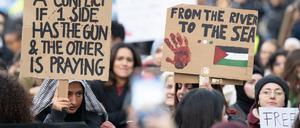 03.11.2023, Hessen, Frankfurt/Main: Junge Frauen halten Plakate mit Aufschriften "It is not a "conflict" if 1 side has the gun & the other is praying" und "From the river to the sea". Mehrere hundert Menschen versammelten sich zu einer pro-palästinensischen Demonstration. Die Kundgebung wurde von einem massiven Polizeiaufgebot begleitet. Foto: Boris Roessler/dpa +++ dpa-Bildfunk +++