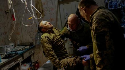 Sanitäter der 5. Angriffsbrigade helfen dem verletzten ukrainischen Soldaten Mykhailo, 42 Jahre alt, in einem medizinischen Stabilisierungspunkt inmitten des russischen Angriffs auf die Ukraine in der Nähe einer Frontlinie in der Region Donezk, Ukraine, 9. November 2023.
