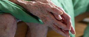 Eine pflegebedürftige Seniorin sitzt auf ihrem Bett. Die Ermittlungen gegen Mitarbeiter eines Pflegedienstes in Berlin geben laut Berliner Gesundheitsverwaltung keinen Anlass zur allgemeinen Sorge.