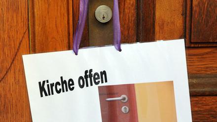 „Kirche offen“. Ein Schild an der Türklinke weist auf die geöffnete evangelische Stadtkirche in Offenbach bei Frankfurt am Main hin (Archiv 19.11.2009).