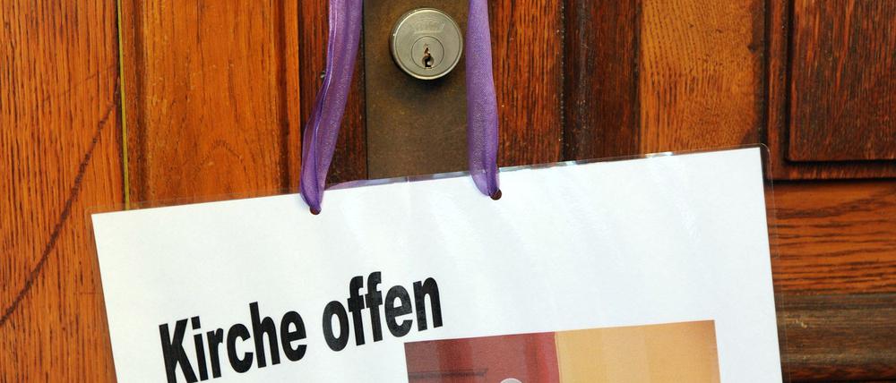 „Kirche offen“. Ein Schild an der Türklinke weist auf die geöffnete evangelische Stadtkirche in Offenbach bei Frankfurt am Main hin (Archiv 19.11.2009).