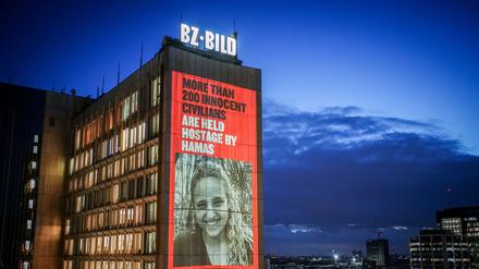 22.01.2021, Berlin: Bilder der mehr als 200 Geiseln der Hamas werden in einem Video mit einer Lichtprojektion am Axel-Springer-Hochhaus gezeigt. Die Aktion ist von israelischen und in Berlin lebenden israelischen Künstlerinnen und Künstlern initiiert und unterstützt. Foto: Kay Nietfeld/dpa - ACHTUNG: Verwendung nur im vollen Format +++ dpa-Bildfunk +++