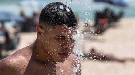 15. November 2023: Ein Mann nimmt an einem Strand von Rio de Janeiro eine Dusche.