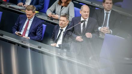 Bundeskanzler Olaf Scholz (SPD) spricht bei der Regierungsbefragung im Bundestag, daneben Christian Lindner (links, FDP), Bundesminister der Finanzen, und Robert Habeck (Mitte, Bündnis 90/Die Grünen), Bundesminister für Wirtschaft und Klimaschutz.