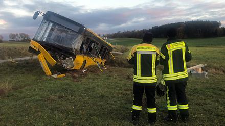 Einsatzkräfte der Feuerwehr neben dem verunglückten Linienbus.