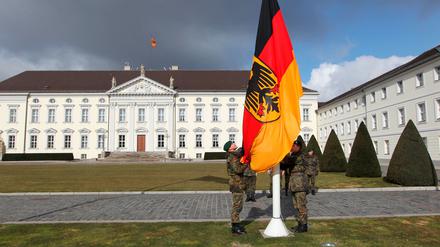 Soldaten des Wachbataillons hissen vor dem Schloss Bellevue in Berlin die Dienstfahne des Bundespräsidenten.