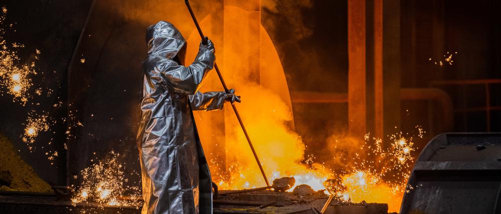 Ein Stahlarbeiter von Thyssenkrupp prüft den Roheisen am Hochofen 8 auf dem Werksgelände.