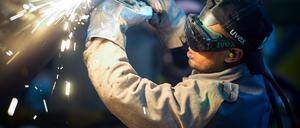 Ein Mann aus Somalia, der zuvor als Schweißer ausgebildet wurde, arbeitet in einer Firma an einem Stahlsegment. 