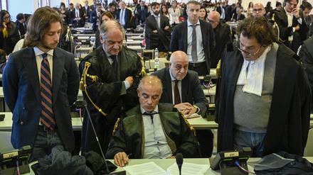 Beamte hören zu, wie Richterin Cavasino die Urteile des Prozesses verliest. In Italiens größtem Mafia-Prozess seit Jahrzehnten ist ein ehemaliger Abgeordneter der Regierungspartei Forza Italia zu elf Jahren Haft verurteilt worden. 