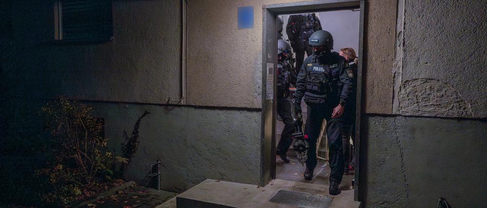 Polizisten verlassen während einer Wohnungsdurchsuchung ein Haus. (Symbolbild)