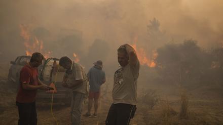 Einheimische auf Rhodos versuchen einen Waldbrand zu löschen. 
