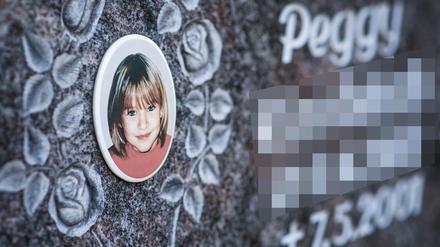 Bayern, Nordhalben: Ein Gedenkstein mit dem Porträt des Mädchens Peggy auf einem Friedhof. 