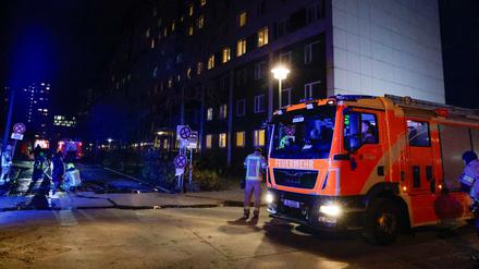 Einsatzkräfte der Feuerwehr stehen bei einem Einsatz vor einem Hochhaus in Berlin-Friedrichshain.
