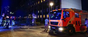 Einsatzkräfte der Feuerwehr stehen bei einem Einsatz vor einem Hochhaus in Berlin-Friedrichshain.