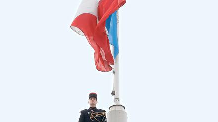 Wachmann hinter der französischen Nationalflagge am Elysee-Palast in Paris